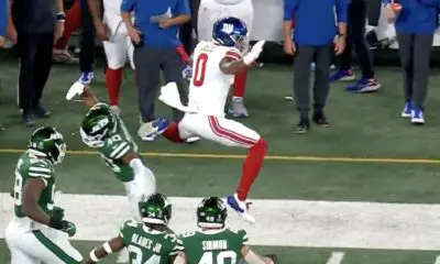 Former New York Giants wide receiver John Jiles hurdles a New York Jets defender in a preseason game. He has signed with the New England Patriots practice squad.